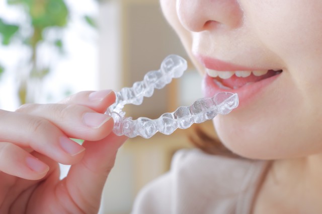 歯科用マウスピースを装着する若い女性