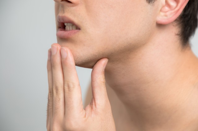 顎を触る男性